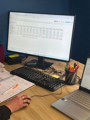 a man that is sitting at a desk with a laptop and a monitor