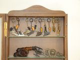 a wooden cabinet with key chains, keys, and other items on it