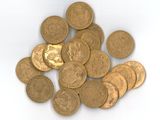 quelques pièces d'or sont éparpillées sur une surface blanche, sur fond blanc