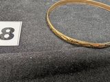 un gros plan d'un bracelet en or portant le chiffre 78