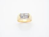 an 18k yellow gold ring set with a baguet cut diamond