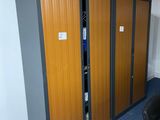 a black chair in a room with two wooden lockers