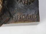 a bronze statue of a man with a hat on