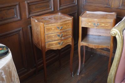 deux tables et chaises en bois dans une pièce aux murs lambrissés