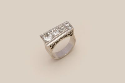a close up of a diamond ring on a white surface