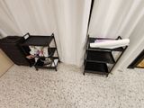 a black shelf with a towel on it next to a black shelf with a white towel on it