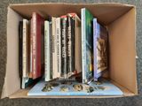 many books in a cardboard box on the floor