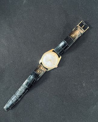 a close up of a watch on a black surface