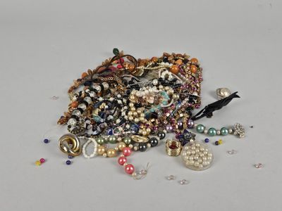 une pile de bijoux assortis sur une surface blanche