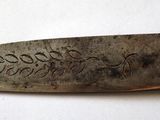 a knife with writing on it sitting on a table