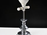 a white vase sitting on a table with a black background