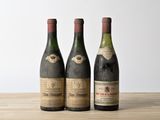 trois bouteilles de vin posées sur une table en bois
