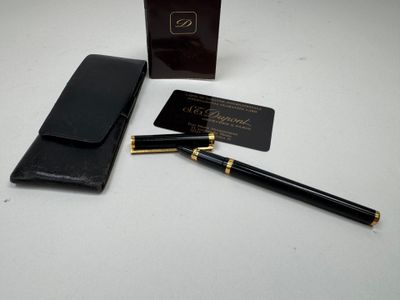 a black pen and a black wallet on a white table