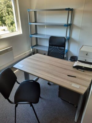 un bureau avec une imprimante et une chaise dans une pièce