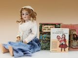 une poupée assise à côté d'un livre