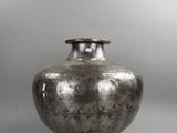 a silver vase that is sitting on a table