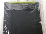 un gros plan sur un sac en tissu noir posé sur une surface blanche
