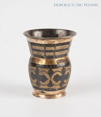 a black and gold vase sitting on a white surface