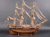 wooden model of a sailing ship on a stand on a gray background