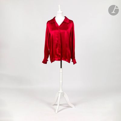 un chemisier rouge posé sur un support de mannequin, avec un mannequin blanc