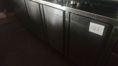 un comptoir en acier inoxydable sur lequel sont posées plusieurs bouteilles