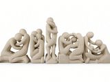a sculpture of a group of people sitting on a white surface