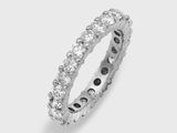 un gros plan d'une bague « éternité » sertie de diamants sur fond blanc