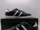 une paire de baskets noires et blanches posée sur une boîte