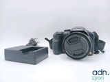a black camera and a charger sitting next to each other