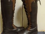 pair of brown boots with laces on top of a blue box