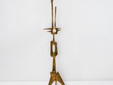 a brass candle holder with two candles on top of it