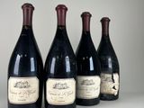 four bottles of wine are lined up on a table