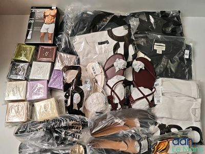 de nombreux sacs contenant des vêtements et des accessoires, disposés sur une table
