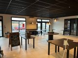 tables and chairs in a restaurant with a sign on the wall