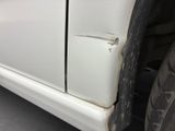 a close up of a white car with a cracked door