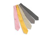 Plusieurs cravates de différentes couleurs sont disposées en rangée sur une surface blanche