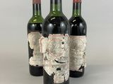 trois bouteilles de vin sur lesquelles figure une carte au dos