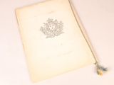an old book with a tassel on top of it on a table