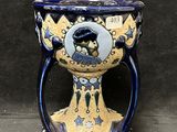 un vase bleu et jaune sur lequel est représenté un homme