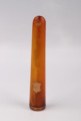 un vase en verre brun orné d'un emblème doré