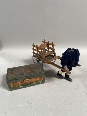 un petit bonhomme tirant une charrette en bois sur laquelle se trouve une caisse en bois