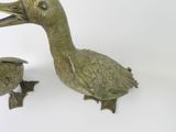 a bronze duck that is next to a small bronze duck