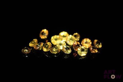 a pile of yellow diamonds on a black surface