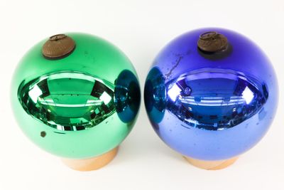pair of blue and green christmas ornaments on a white surface