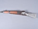 an old rifle with a wooden handle on a white surface