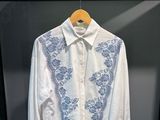 une image représentant une chemise blanche ornée d'un motif floral bleu