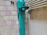 a green fire hydrant next to a blue fire hydrant on a brick wall