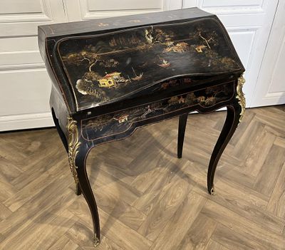bureau peint en noir et or, avec des tiroirs et des tiroirs sur le dessus