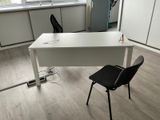 a white desk with a black chair next to it