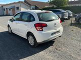 the small white car is parked in the parking lot